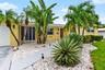 Tropical landscaping frames the front of the home.
