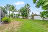 Backyard lawn bordered by tropical landscaping.