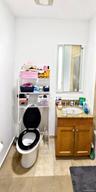 Built-in vanity with a granite countertop, undermount sink, and wood-finish cabinetry