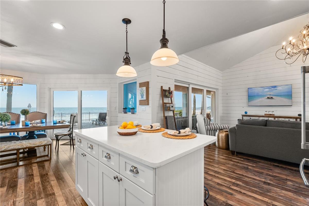 Spacious eat-in kitchen with stainless steel appliances, quartz countertops, breakfast bar seating, and beautiful ocean views—an inviting setting for 