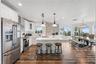 Spacious eat-in kitchen with stainless steel appliances, quartz countertops, breakfast bar seating, and beautiful ocean views—an inviting setting for 
