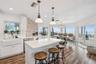 Spacious eat-in kitchen with stainless steel appliances, quartz countertops, breakfast bar seating, and beautiful ocean views—an inviting setting for 