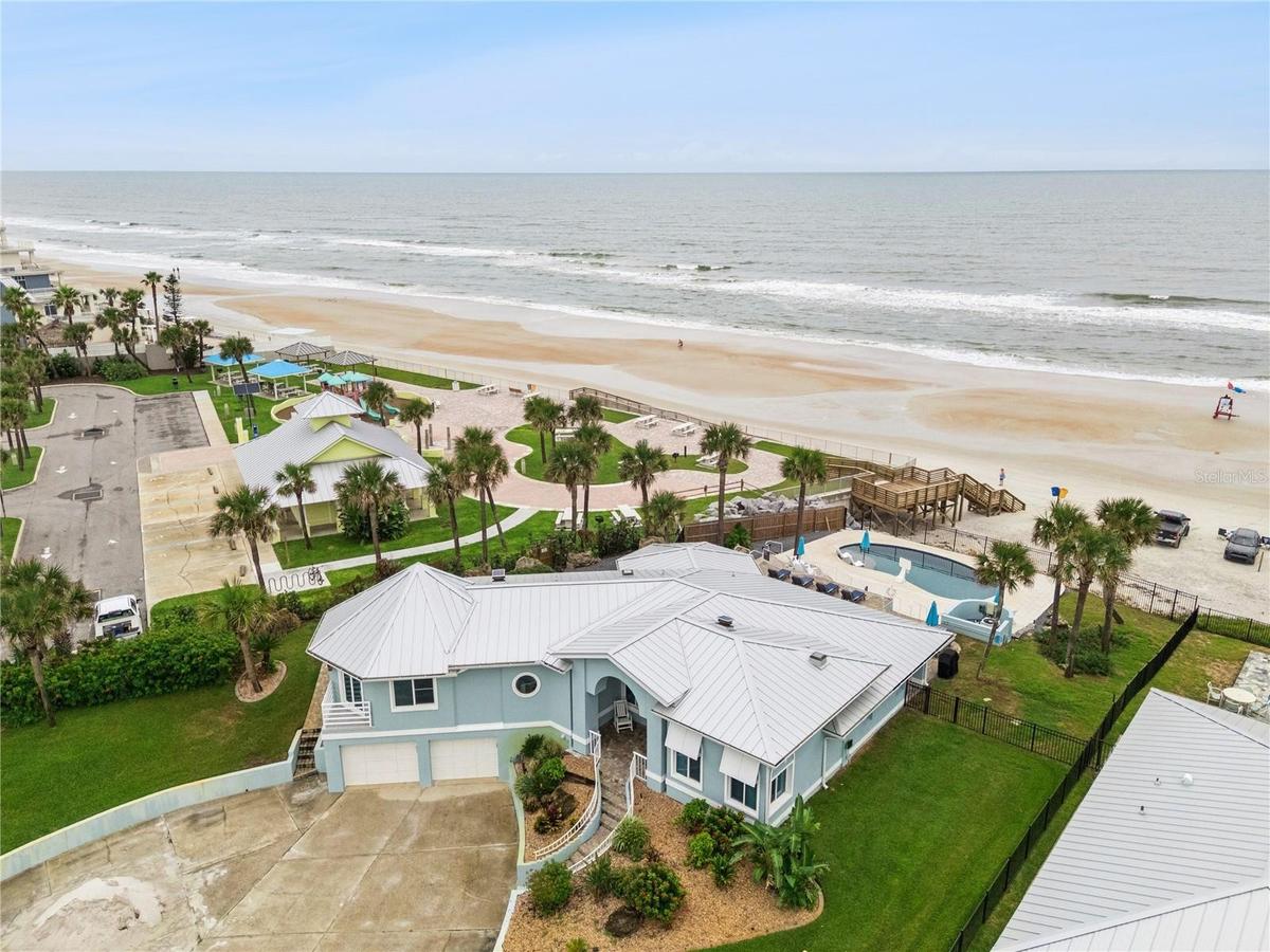 Set on over three-quarters of an acre with approximately 85 feet of ocean frontage, this property offers a generous setback from the road, ample drive