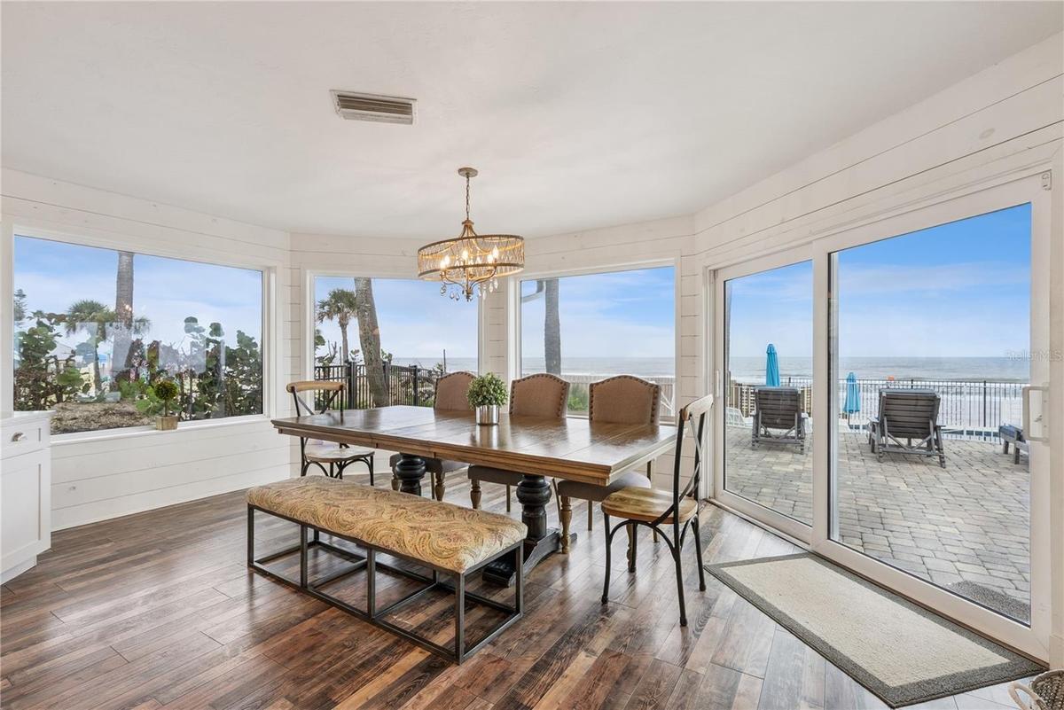 Spacious eat-in kitchen with stainless steel appliances, quartz countertops, breakfast bar seating, and beautiful ocean views—an inviting setting for 