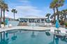 New oceanfront pool installed in 2024, featuring heating, a sun shelf, bubblers, and a 7-foot-deep end, with expansive patio space and panoramic Atlan