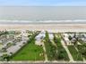Set on over three-quarters of an acre with approximately 85 feet of ocean frontage, this property offers a generous setback from the road, ample drive
