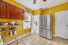 Kitchen featuring tile flooring, wood-finish cabinetry, and a window with blinds
