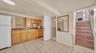 Kitchenette featuring wood cabinetry, stone-look countertops, and tile flooring