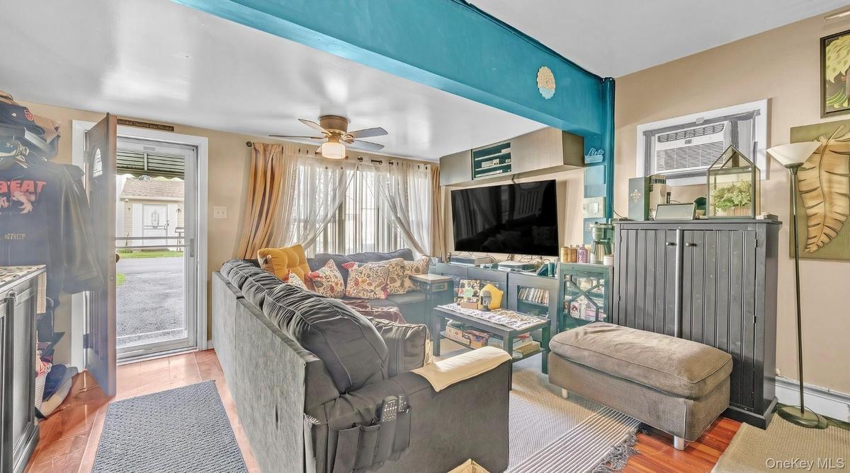 Wood-finish flooring, ceiling fan, and window-mounted air conditioning unit