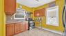 Kitchen featuring wood cabinetry, granite-style countertops, tile backsplash, and stainless steel appliances