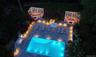 Rectangular swimming pool surrounded by a paver patio with integrated lighting
