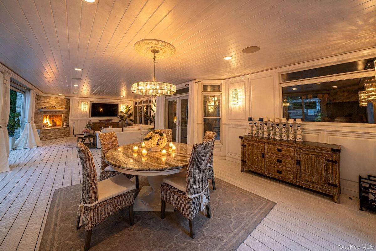 Shiplap ceiling with recessed lighting and a central chandelier