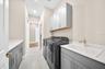 Large laundry room with laundry sink and lots of storage