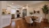 Hardwood flooring, recessed lighting, white cabinetry, stainless steel appliances, and a tiled backsplash Digitally staged