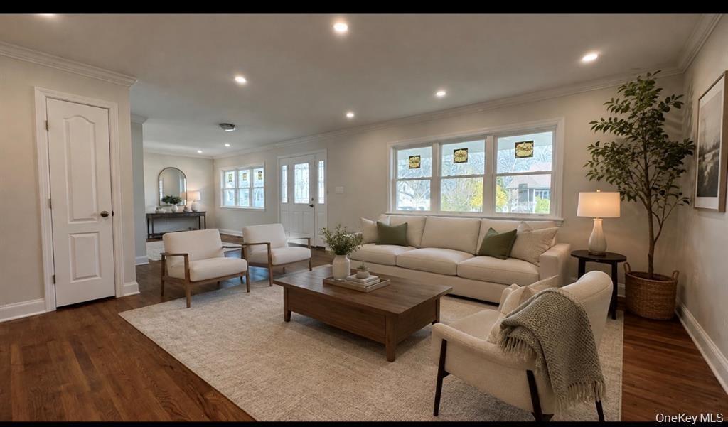 Wood-finish flooring, recessed lighting, crown molding, multiple windows, and a panel-style door Digitally staged