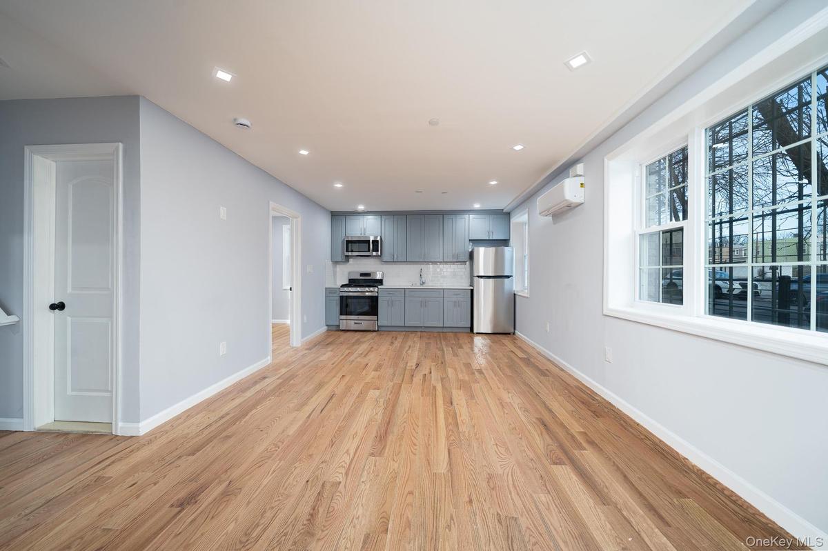 Unfurnished living room featuring recessed lighting, light wood-style floors, and a wall mounted air conditioner