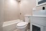 Bathroom with vanity, shower / bathtub combination, and tile walls