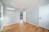 Unfurnished room featuring light wood finished floors and a wall mounted air conditioner