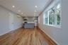 Kitchen featuring gray cabinetry, open floor plan, light countertops, light wood finished floors, and stainless steel appliances