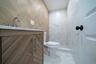 Full bathroom with vanity, tile walls, a marble finish shower, and marble look tiles