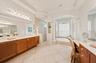 Spacious en-suite bathroom features separate vanities, a soaking tub, and a walk-in shower.