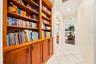 Custom built-in wooden shelving and cabinetry provide extensive display and storage space in the hallway.