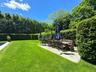 View of green lawn with a patio