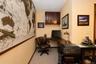 L shaped office  with corner configuration, recessed lighting, upper wood-finish cabinetry and door to rear deck