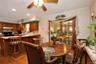 Wood-finish flooring, wood cabinetry, built-in ceiling lighting, and a ceiling fan Peninsula with storage and entrance to the bonus room