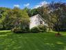 Side yard with mature landscaping and trees