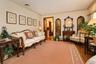 Hardwood flooring, crown molding, and a decorative area rug define this inviting space