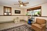 Wood-finish window trim, ceiling fan, and painted walls with accent trim