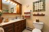 Warm-toned vanity with an integrated sink, ample storage cabinetry and tub/shower