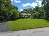 Front of the home with manicured lawn and new paved driveway