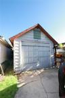 Detached garage with horizontal siding, a gable roof, and an overhead garage door