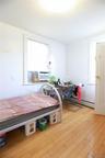 Hardwood flooring, painted white walls, white trim, and a window with a window-mounted air conditioning unit