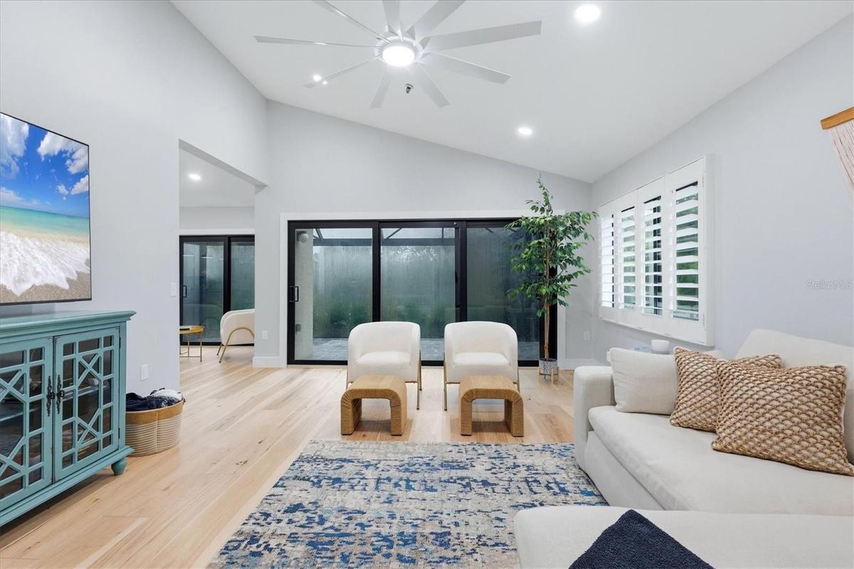 Living room opens to lanai with new screened enclosure and new stone pavers