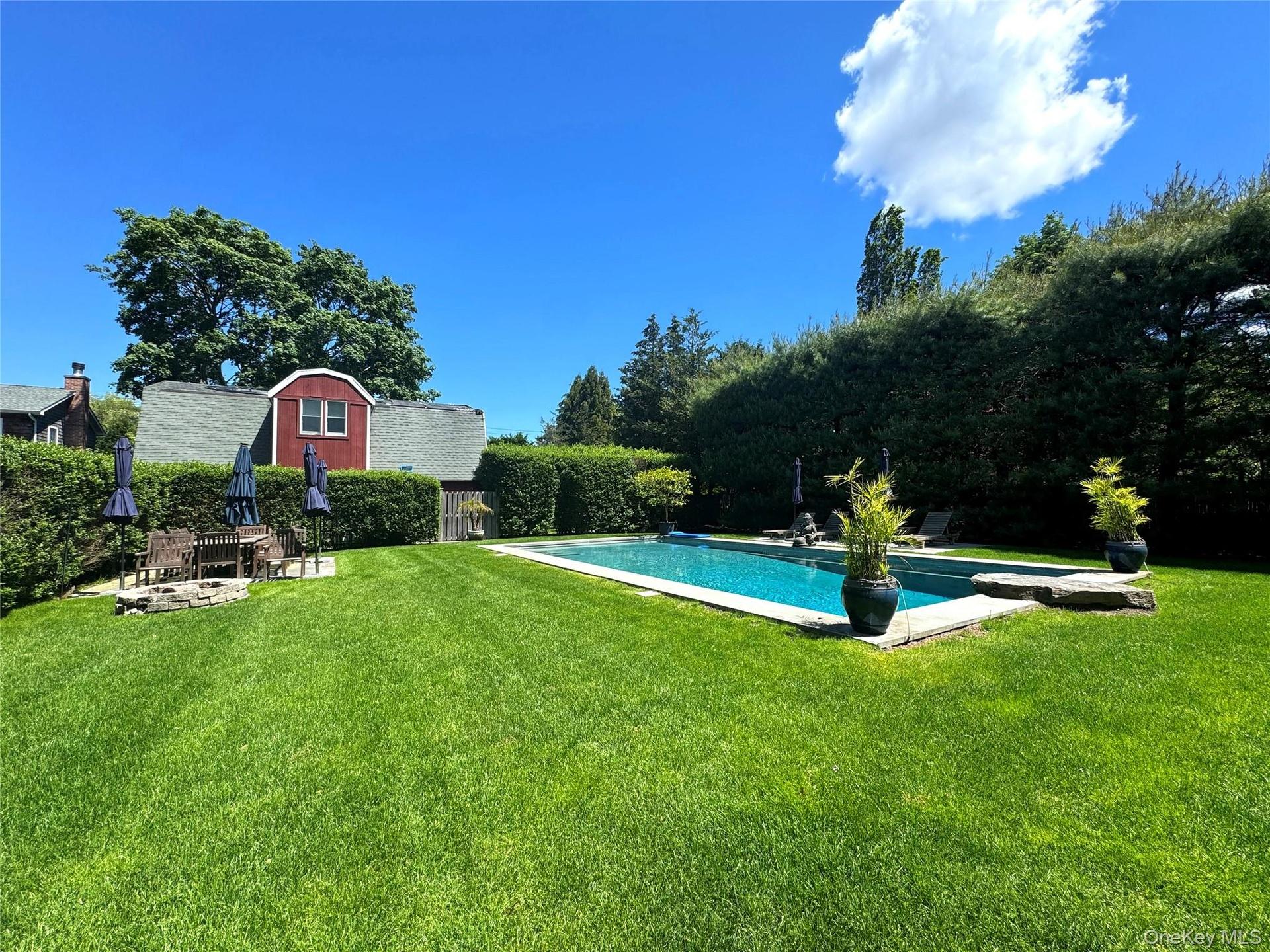 Outdoor pool featuring a lawn