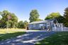 Additional perspective showcasing the home, driveway and surrounding green space.