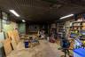 Enclosed work area within the barn featuring shelving, overhead lighting and ample workspace.
