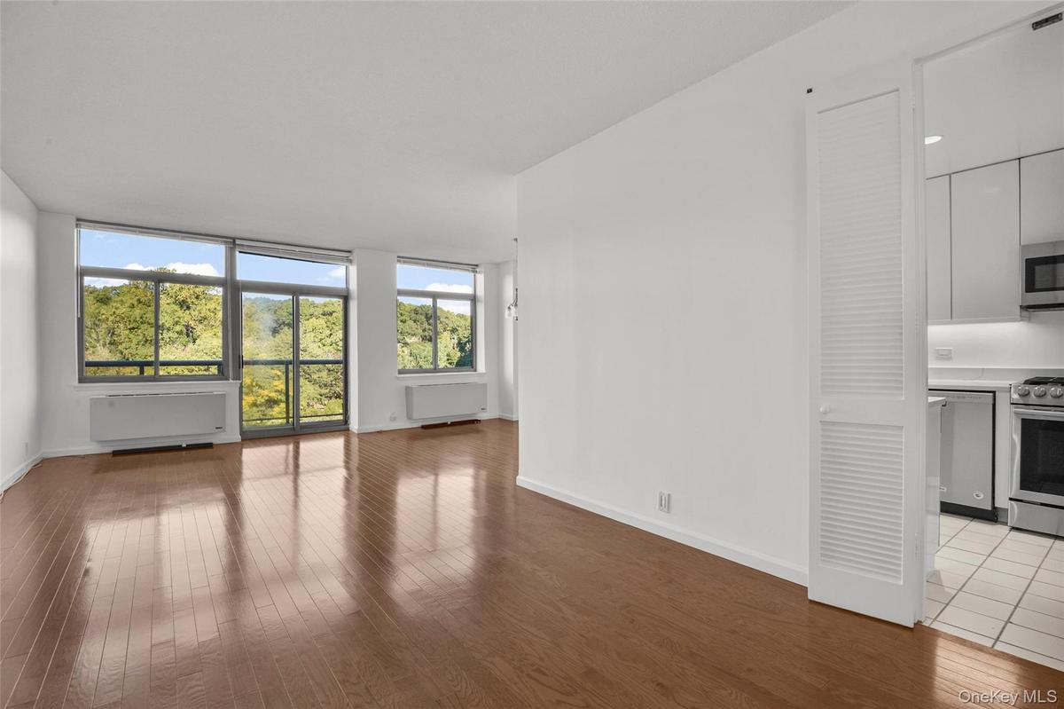 Living Room with Door to Terrace and Tree Top/Sky line View with Beautiful Hardwood Floors