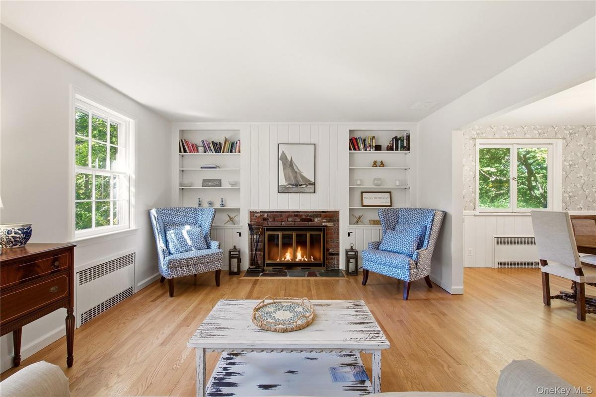 Formal living room has wood burning fireplace and overlooks front yard