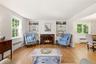 Formal living room has wood burning fireplace and overlooks front yard