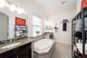 Spacious primary bath with a walk-in shower, dual vanities, and a relaxing soaking tub.