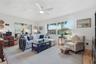Sunlight pours through a wide window in the family room, while sliding glass doors connect this comfortable gathering space to the enclosed Florida ro