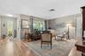 Natural light and garden views bring warmth to the front living room, creating an inviting setting for conversation or a quiet afternoon.