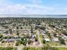 A wider aerial perspective places the home within its leafy St. Petersburg neighborhood, with the bay and Sunshine Skyway Bridge on the horizon.
