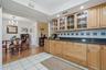 Glass-front cabinetry adds charm above an expansive counter, perfect for meal preparation or serving a spread just steps from the dining table.
