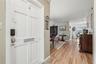An inviting entry opens to comfortable living spaces, with warm wood flooring connecting the living and dining areas.