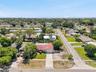 See the corner setting from above, with a broad driveway, mature trees, and generous outdoor space surrounding the home.